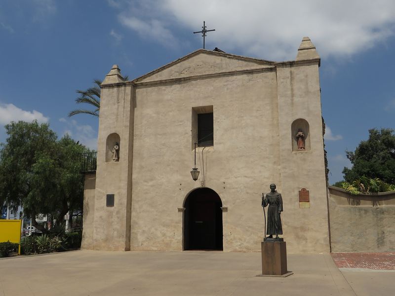 Front of Mission San Gabriel Arcángel with its arched doorway and bell niches